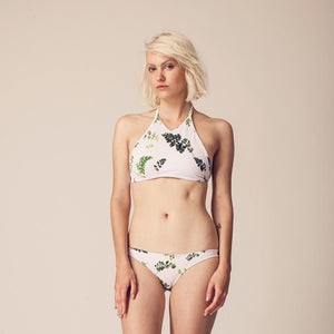 Blonde woman wearing leaf print two piece swimsuit